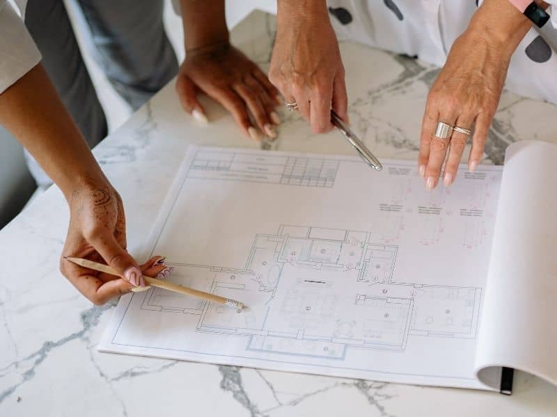 Team reviewing survey records and property plans before updating an older site.